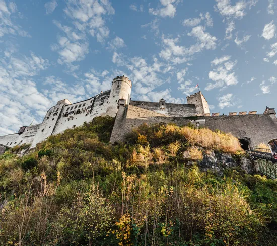 Historic Hohensalzburg Fortress on hilltop with funicular railway and blue sky